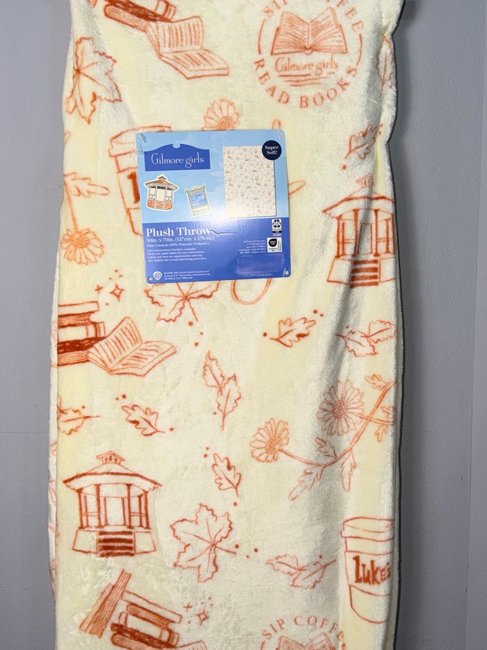 Warner Bros. Gilmore Girls Plush Throw in Cream and Orange Book & Leaf Design